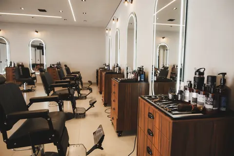 Fileira de cadeiras de barbeiro e bancadas de madeira da Barbearia Montreal em Cascavel
