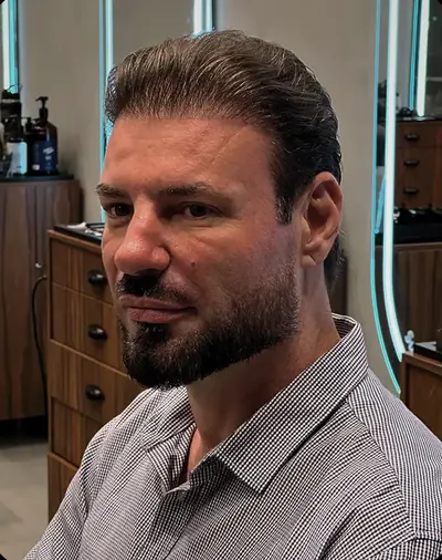 Corte masculino penteado para trás com barba desenhada