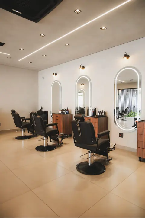 Estações de corte com espelhos iluminados na Barbearia Montreal