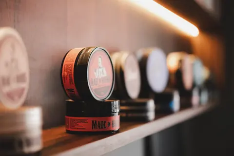 Pomadas modeladoras expostas na barbearia