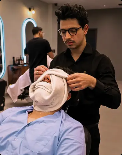 Barbeiro preparando a barba do cliente com toalha quente